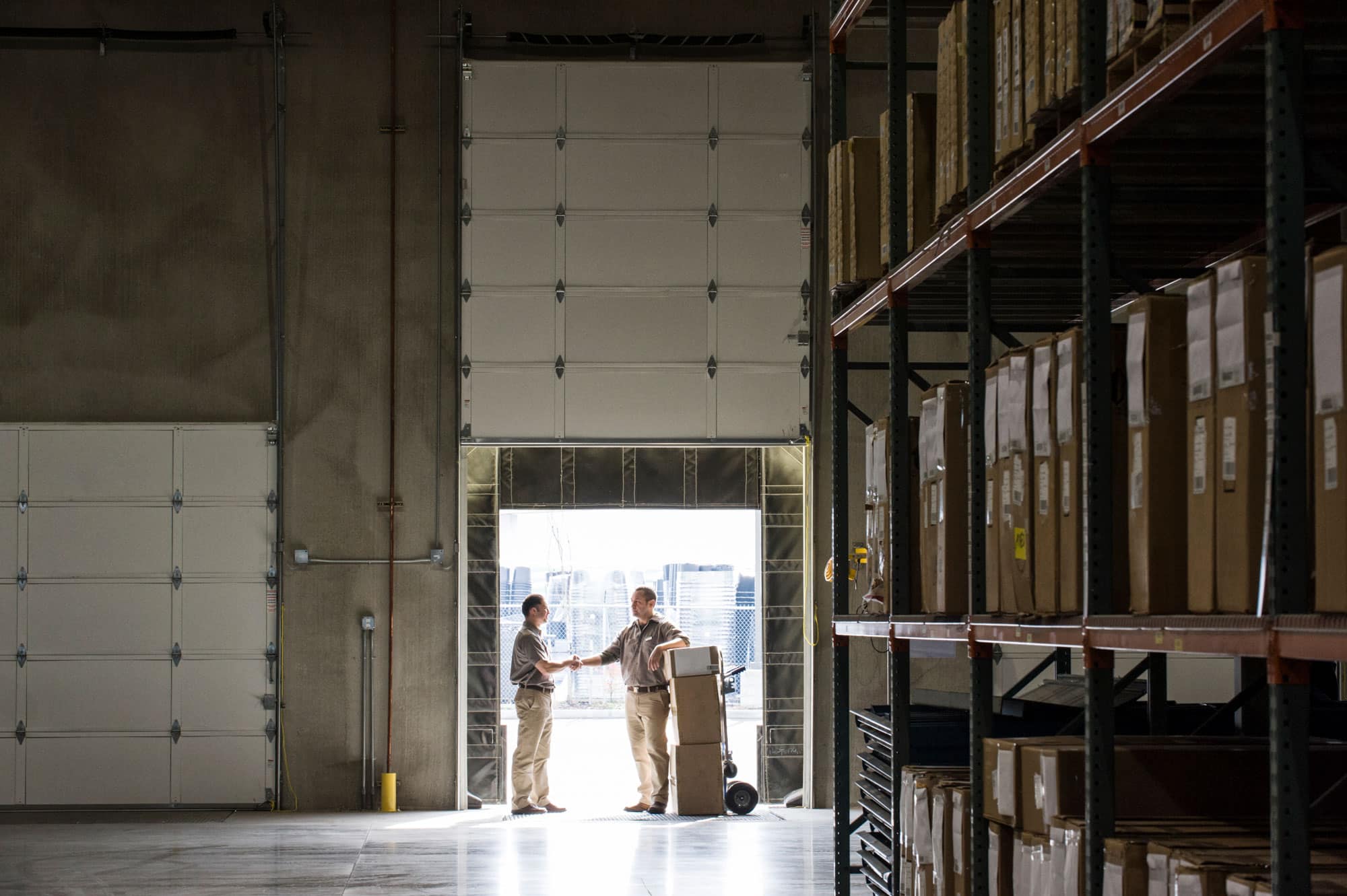 two warehouseworkers shaking hands in the door of 2023 11 27 05 35 14 utc