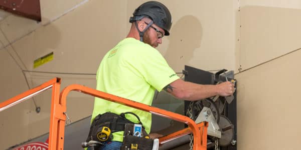 Technician performing maintenance on a commercial door