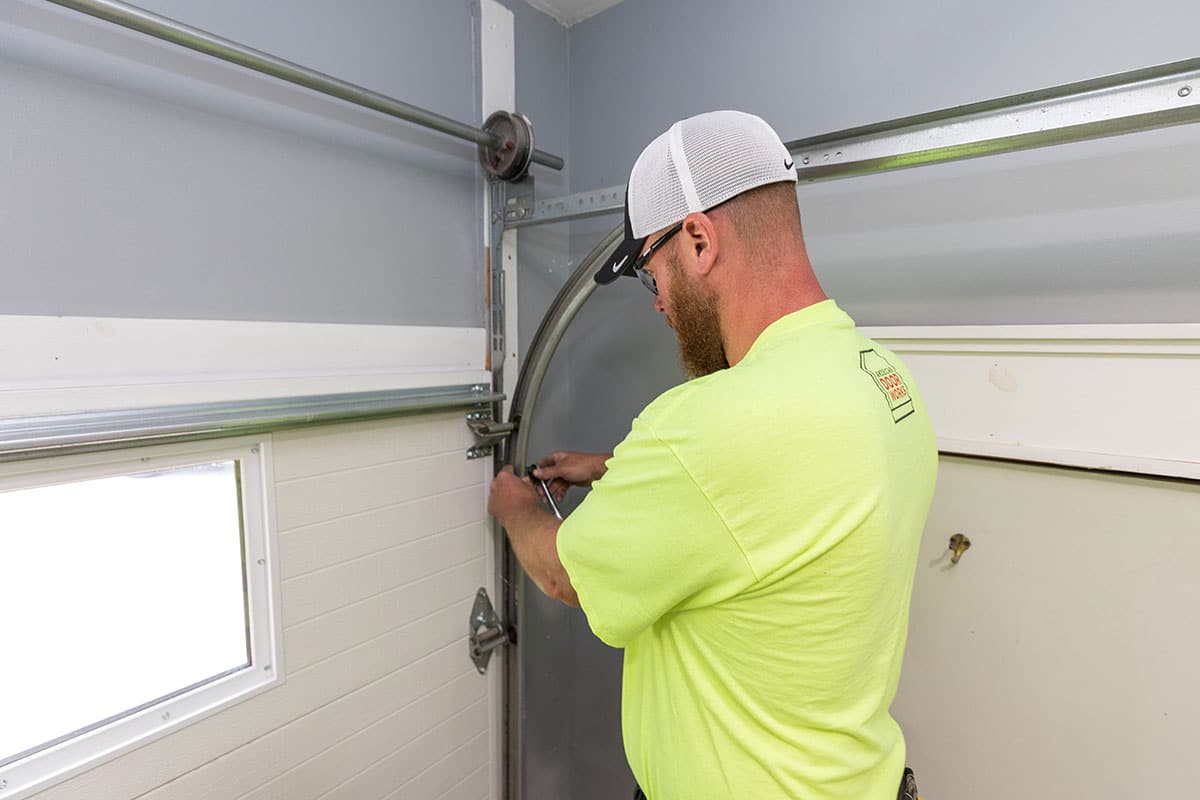 American Door Works team member applying service to garage door